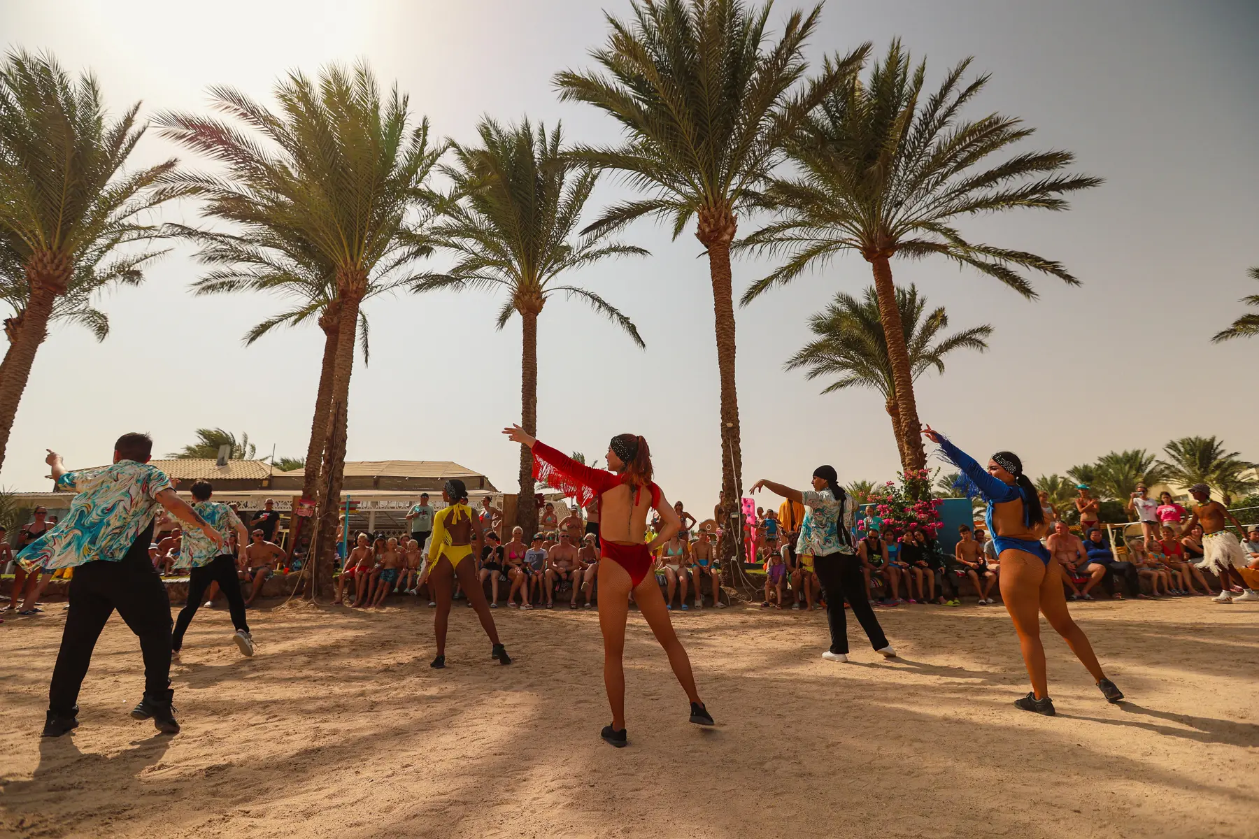 Guests joining a beach dance animation activity led by entertainers at Caribbean World Resorts Hurghada